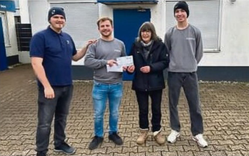 Azubis stehen neben Vorstandsmitglied der Tafel Dietzenbach Frau Kwoka