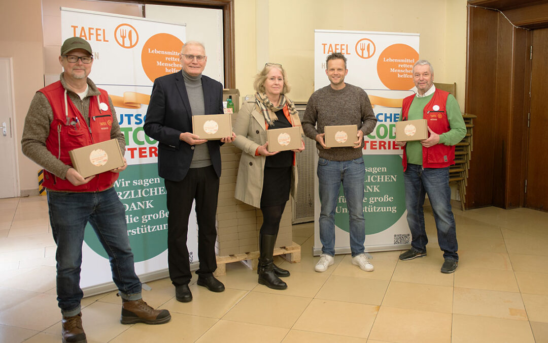 Gruppenfoto von Unterstützern und Vertretern der Tafel Hessen, die gespendete Geschenkboxen der Deutschen Postcode Lotterie präsentieren – aufgenommen bei der Herbstaktion in Hessen.